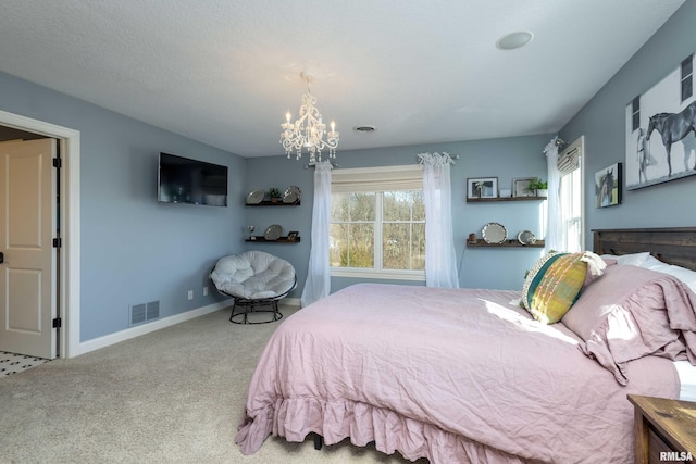 carpeted bedroom featuring an inviting chandelier