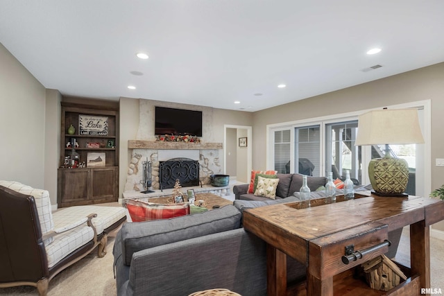 carpeted living room featuring a stone fireplace