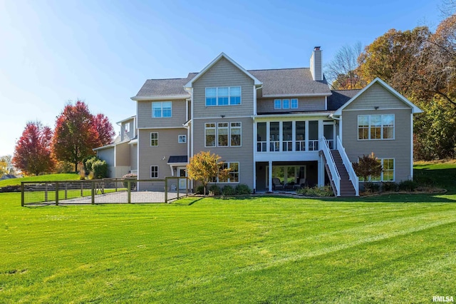 back of property featuring a lawn and a sunroom