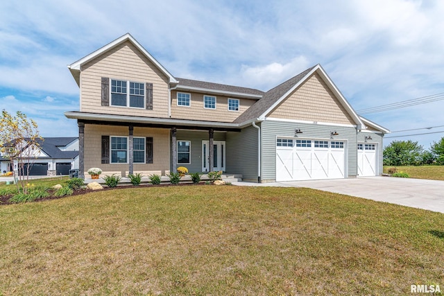 view of front of home featuring covered porch, a garage, and a front yard