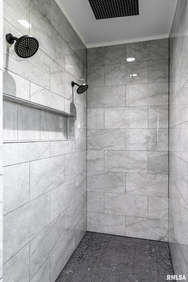 bathroom featuring a tile shower and ornamental molding