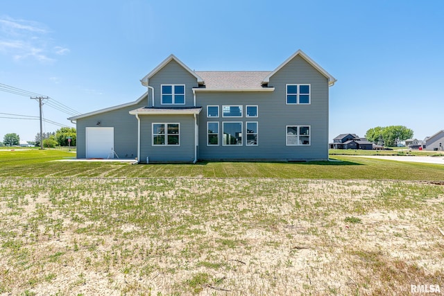 rear view of property with a yard and a garage