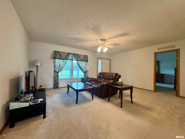 living room with carpet floors, a textured ceiling, and ceiling fan