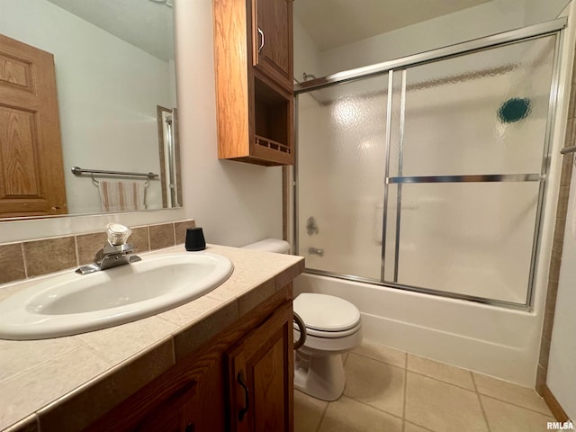 full bathroom with enclosed tub / shower combo, vanity, tile patterned flooring, and toilet