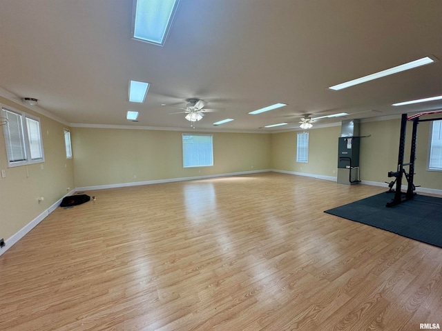 workout room with plenty of natural light, ceiling fan, and light hardwood / wood-style flooring