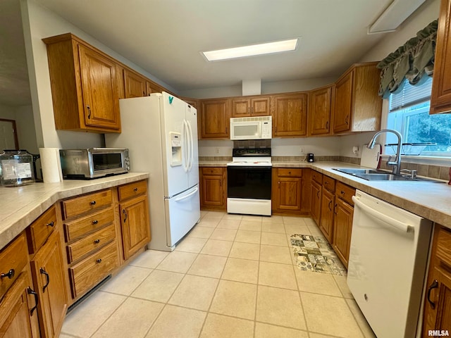 kitchen with white appliances, sink, and light tile patterned floors