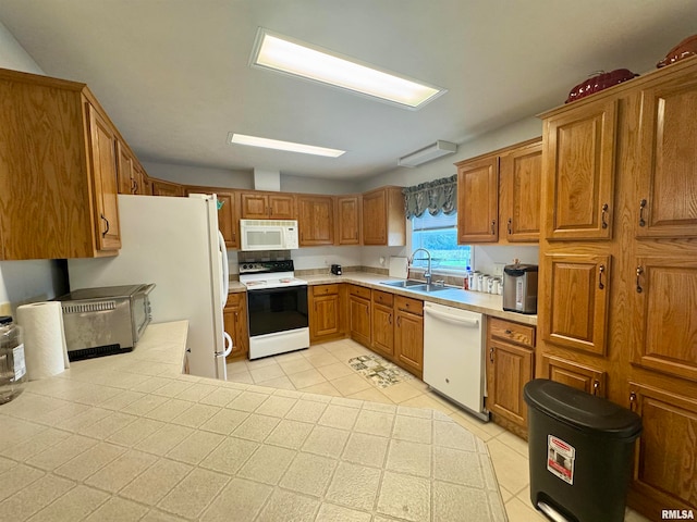 kitchen featuring white appliances, light tile patterned floors, and sink