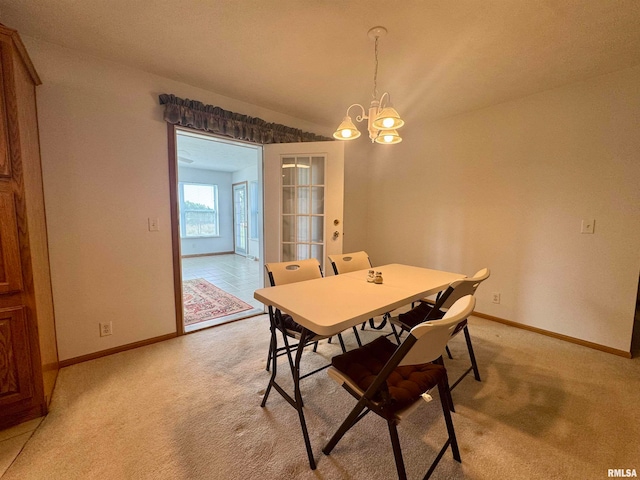 carpeted dining space featuring an inviting chandelier and vaulted ceiling