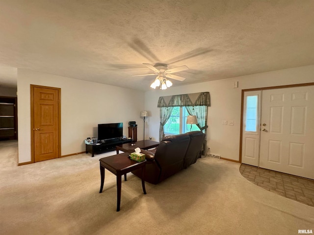 carpeted living room featuring ceiling fan and a textured ceiling