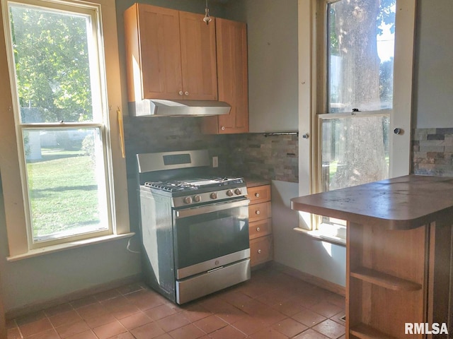 kitchen with backsplash, stainless steel gas stove, and light tile patterned floors