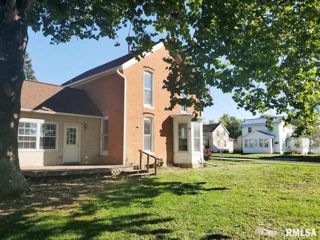 rear view of house featuring a yard