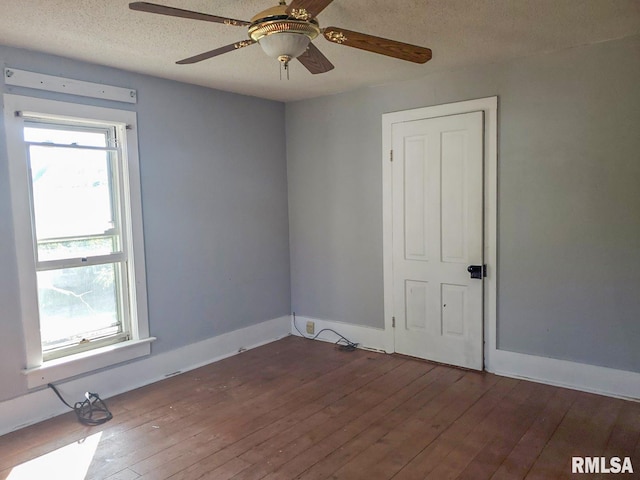 unfurnished room with a textured ceiling, dark hardwood / wood-style flooring, and ceiling fan