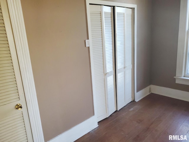 unfurnished bedroom featuring dark hardwood / wood-style floors and a closet