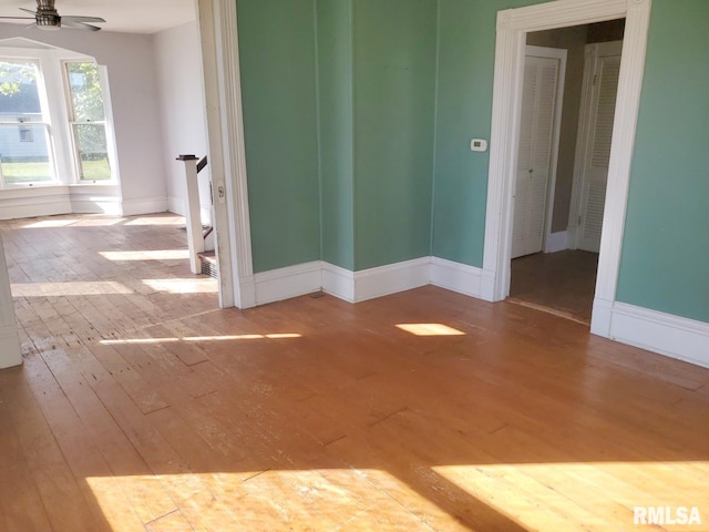 empty room with ceiling fan and light hardwood / wood-style flooring