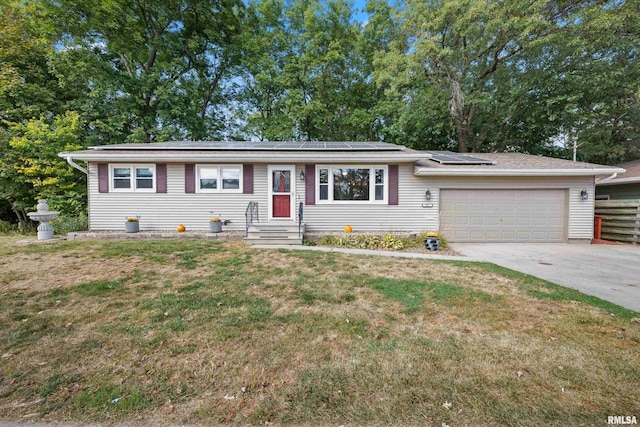 ranch-style home with a garage, a front lawn, and solar panels