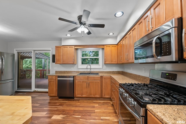 kitchen featuring light wood-type flooring, appliances with stainless steel finishes, a healthy amount of sunlight, and sink