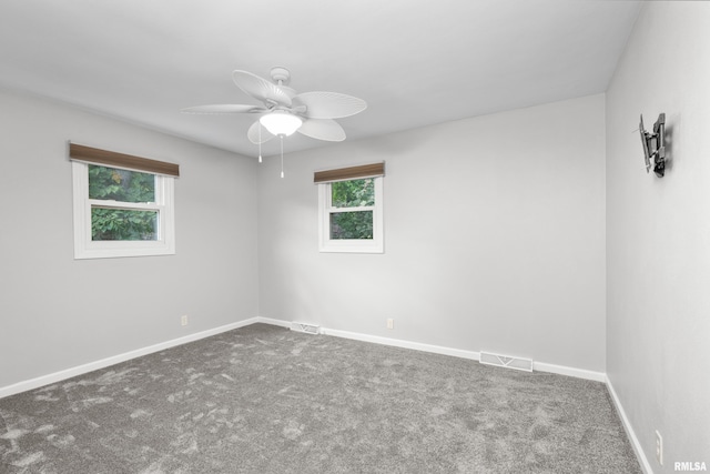 carpeted empty room featuring a wealth of natural light and ceiling fan