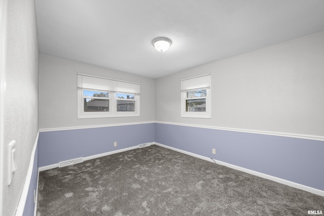 empty room featuring dark colored carpet