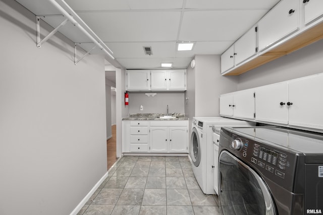 laundry room with washing machine and dryer, sink, light tile patterned floors, and cabinets