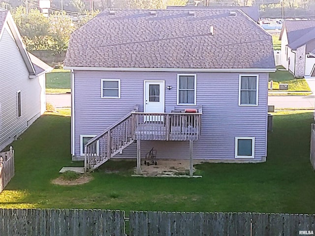 back of house with a deck and a yard