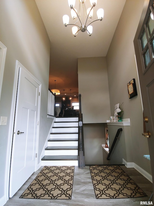 stairway featuring a notable chandelier