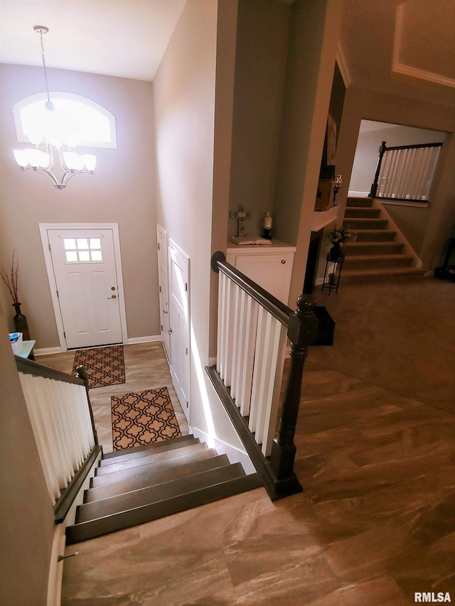 entrance foyer featuring a high ceiling, hardwood / wood-style flooring, and a notable chandelier