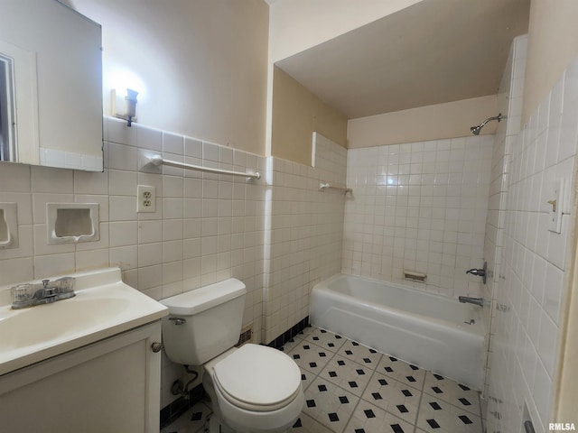 full bathroom with tiled shower / bath, vanity, toilet, and tile walls