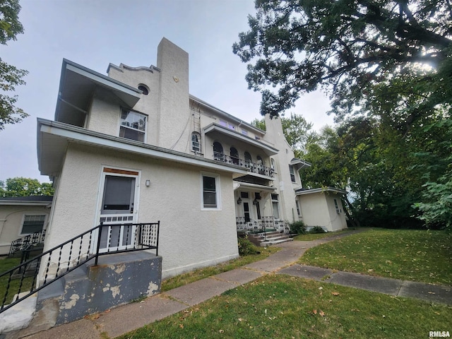 exterior space with a front lawn and a balcony