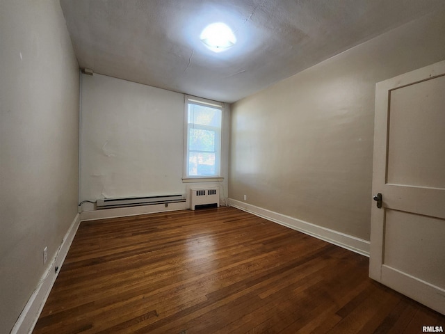 spare room featuring a baseboard radiator, radiator, and dark hardwood / wood-style flooring