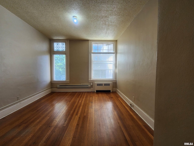 empty room with a baseboard radiator, a textured ceiling, dark hardwood / wood-style floors, and radiator