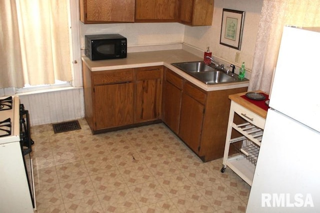 kitchen featuring white appliances and sink