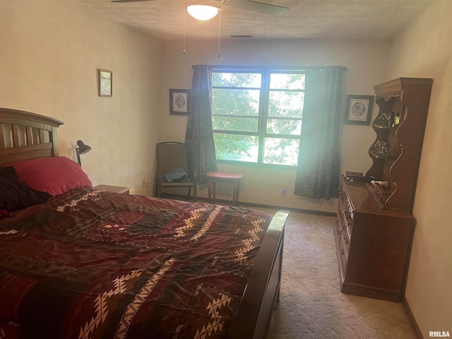 carpeted bedroom featuring a textured ceiling and ceiling fan