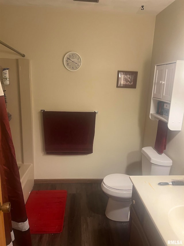 full bathroom with hardwood / wood-style floors, shower / tub combo with curtain, vanity, and toilet