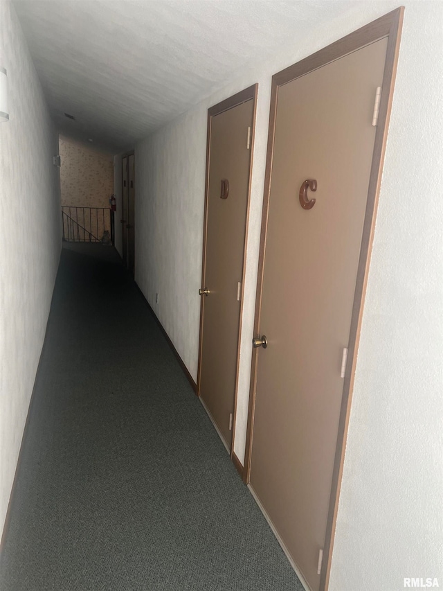 hallway featuring a textured ceiling and carpet floors