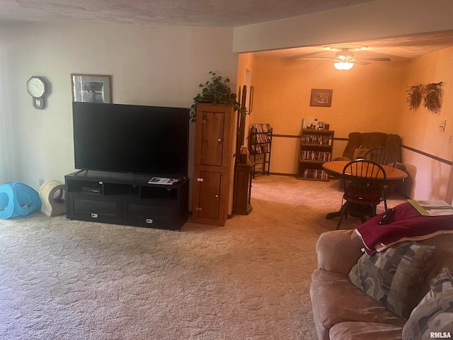 living room featuring ceiling fan, light colored carpet, and a textured ceiling