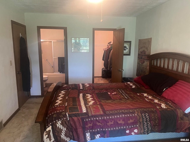 bedroom featuring a closet, ensuite bath, carpet flooring, and a walk in closet