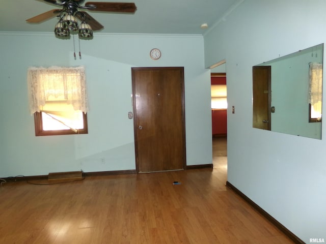 empty room with ceiling fan, light hardwood / wood-style flooring, and ornamental molding