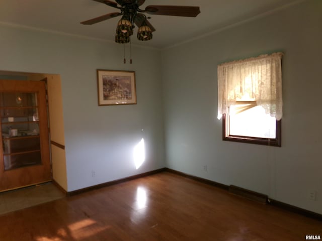 empty room with crown molding, ceiling fan, and hardwood / wood-style flooring