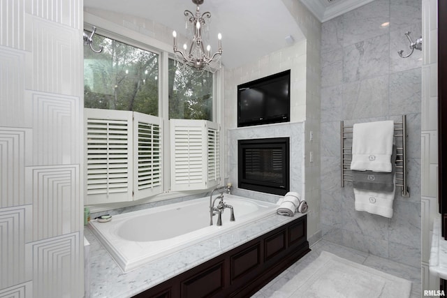 bathroom with tiled tub, an inviting chandelier, tile walls, and a large fireplace