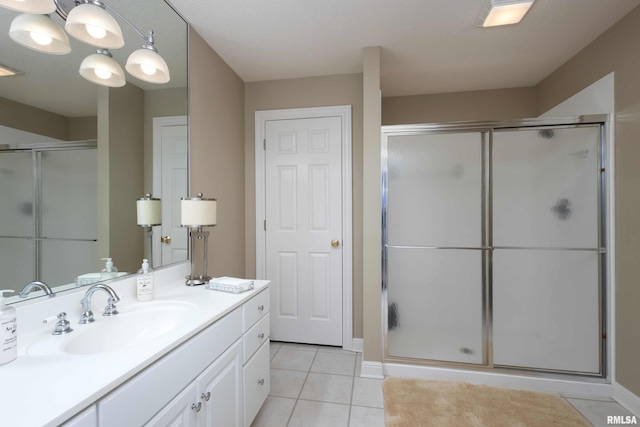 bathroom featuring tile patterned flooring, walk in shower, and vanity