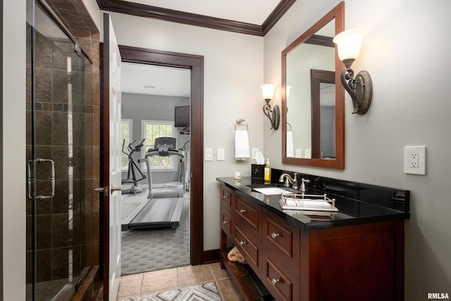 bathroom with tile patterned flooring, a shower with door, vanity, and crown molding