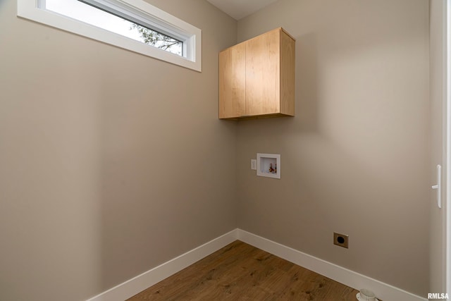 clothes washing area featuring cabinets, hookup for an electric dryer, washer hookup, and hardwood / wood-style flooring