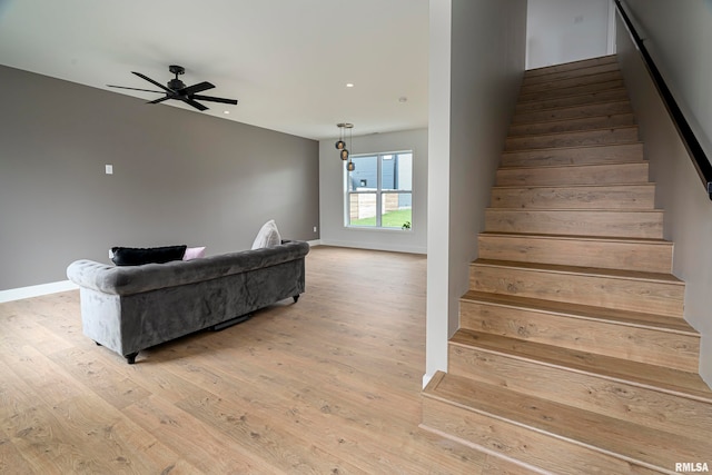 stairway with wood-type flooring and ceiling fan