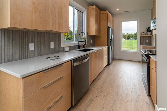 kitchen with light hardwood / wood-style flooring, light brown cabinetry, appliances with stainless steel finishes, and sink