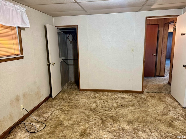 carpeted spare room featuring a paneled ceiling