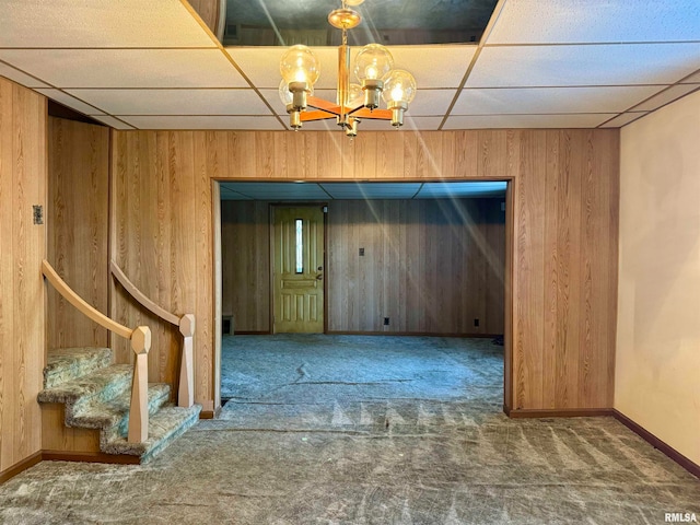 unfurnished dining area featuring carpet floors and wood walls