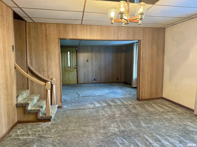 empty room featuring wooden walls and carpet flooring