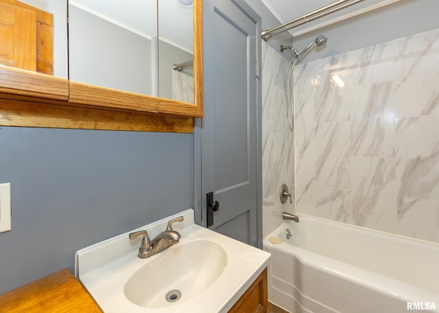 bathroom featuring tiled shower / bath combo and vanity