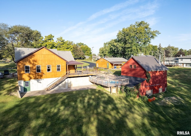 rear view of property featuring a lawn and a storage unit