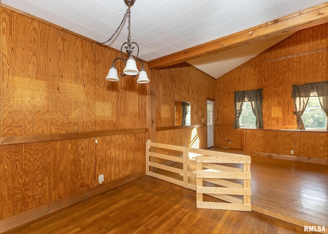 interior space featuring wood walls, vaulted ceiling, dark hardwood / wood-style floors, and a chandelier